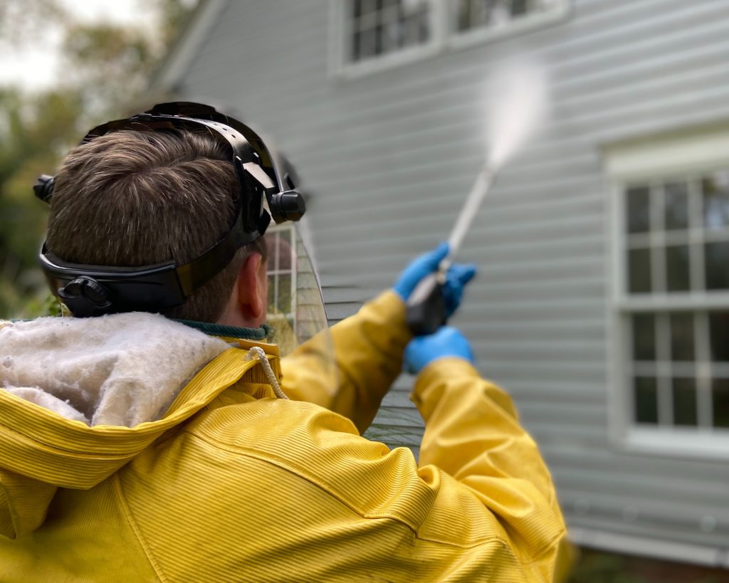 A man power washing a house.