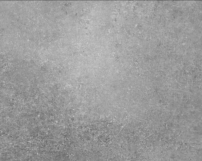 An image of a grey concrete background after undergoing pressure washing.