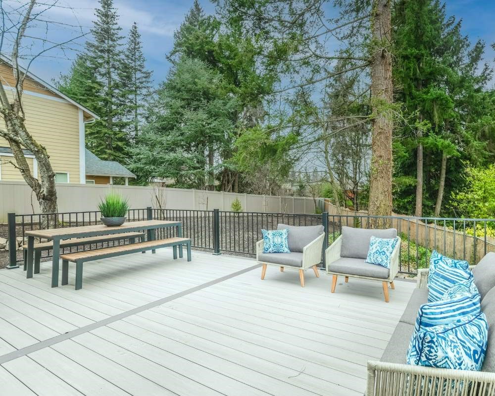 A pressure washed backyard deck with a table and chairs.